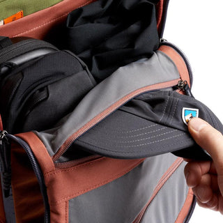 Bellroy Venture Ready Pack 20L showing interior organized compartments with fabric and a hand placing a cap