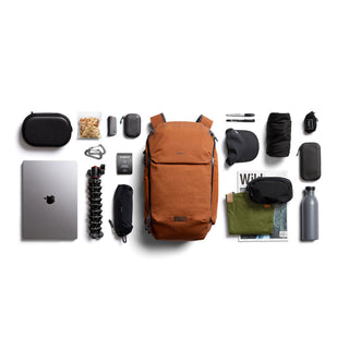 Bellroy Venture Ready Pack 20L in rust with organized travel accessories and tech gear on white background