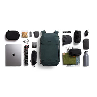 Bellroy Venture Ready Pack 20L in dark green with organized travel and tech accessories laid out flat