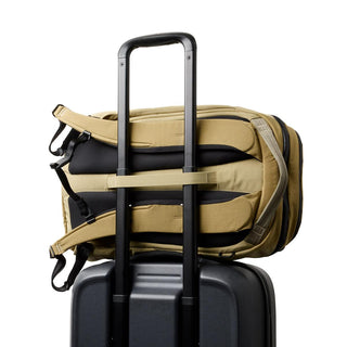 Bellroy Venture Ready Pack 20L in tan secured on black suitcase handle with padded straps visible