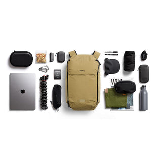 Bellroy Venture Ready Pack 20L in tan with organized travel essentials and tech accessories laid out symmetrically