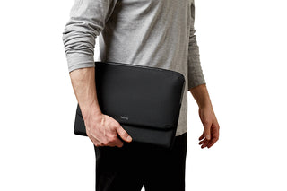 Bellroy Laptop Caddy 14" in black nylon held by person wearing grey long sleeve top