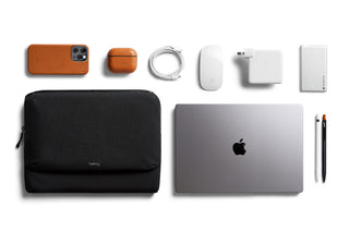 Bellroy Laptop Caddy 14" in black fabric alongside laptop, phone, charger, mouse, and accessories arranged neatly