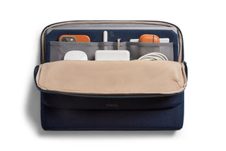 Bellroy Laptop Caddy 14" navy with beige flap, organized tech accessories in multiple pockets visible