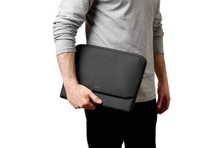 Bellroy Laptop Caddy 14 black slim laptop sleeve held by person in casual grey shirt