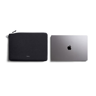 Bellroy Lite Laptop Sleeve 14" in black recycled fabric shown next to a closed silver laptop