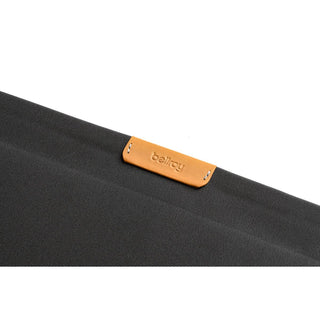 Bellroy Laptop Sleeve 16" close-up showing black recycled fabric and tan leather brand label