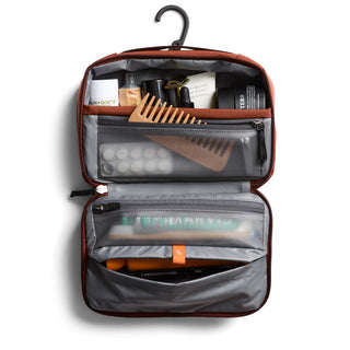 Bellroy Hanging Toiletry Kit open showing organized compartments with travel-sized personal care items and a comb