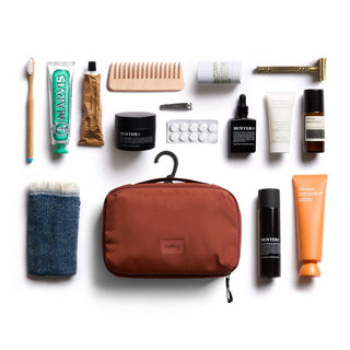 Bellroy Hanging Toiletry Kit in rust color with organizer hook and travel essentials neatly arranged