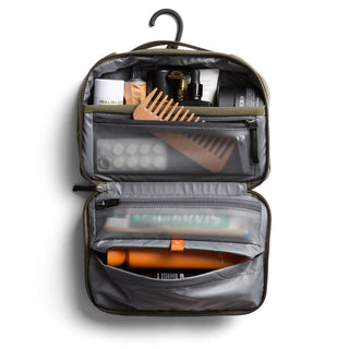 Bellroy Hanging Toiletry Kit open showing organized compartments with grooming items and wooden comb inside