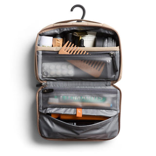 Bellroy Hanging Toiletry Kit open with organized travel essentials and built-in hook in neutral tan color