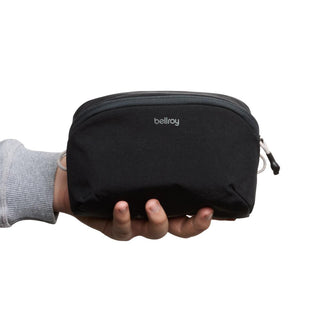 Bellroy Lite Packing Pouch 2L in black recycled fabric held by hand showing compact size and zipper details