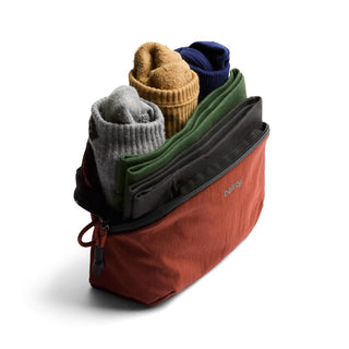 Bellroy Lite Packing Pouch 2L in rust color with textured recycled fabric holding folded clothes upright