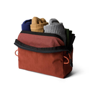Bellroy Lite Packing Pouch 2L in rust fabric partially unzipped with folded socks inside