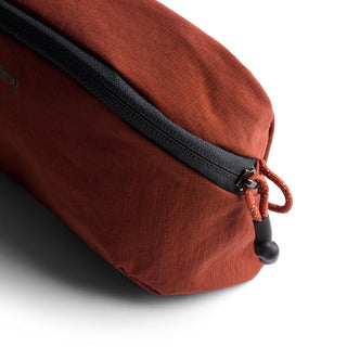 Bellroy Lite Packing Pouch 2L in burnt orange with durable zipper and recycled nylon fabric texture close-up