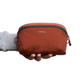Bellroy Lite Packing Pouch 2L in burnt orange held in hand showing fabric texture and compact size