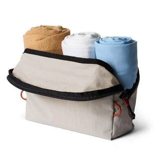 Bellroy Lite Packing Pouch 3L in beige with rolled clothing inside, showing durable recycled fabric texture