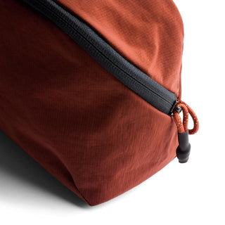 Bellroy Lite Packing Pouch 3L in rust fabric with black zipper and textured recycled nylon material close-up