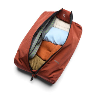 Bellroy Lite Packing Caddy 8L in rust red fabric holding folded clothes and organized packing accessories