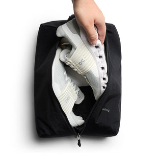 Bellroy Lite Packing Caddy 10L in black with shoes inside, featuring recycled nylon fabric and zipper closure