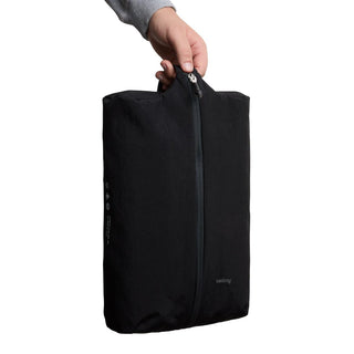 Bellroy Lite Packing Caddy 10L in black recycled nylon held by hand with central zipper detail