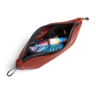 Bellroy Lite Pouch Duo in rust red with zipper, showing organized travel essentials inside compartments