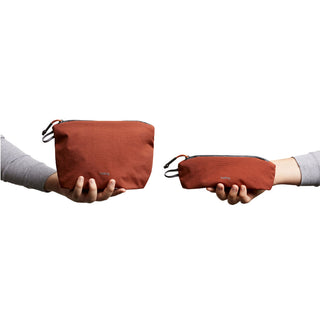 Bellroy Lite Pouch Duo in rust recycled nylon held by hands showing two pouch sizes side by side