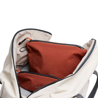 Bellroy Lite Pouch Duo set in rust fabric inside an open beige backpack with black zippers