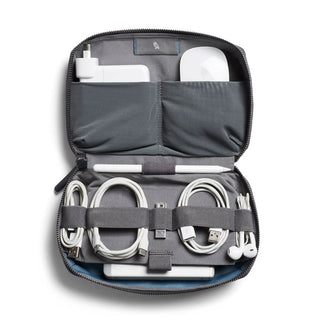Bellroy Tech Kit in gray with organized compartments holding cables, charger, earbuds, and pen inside