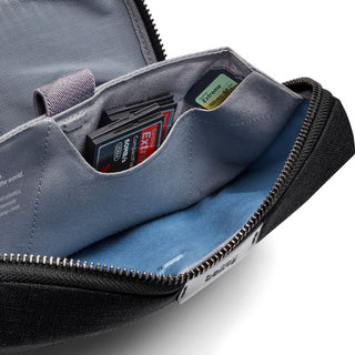Bellroy Tech Kit open showing organized compartments with memory cards inside and black exterior fabric