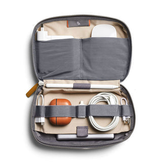 Bellroy Tech Kit open showing organized compartments with charger, cables, and accessories in recycled fabric case