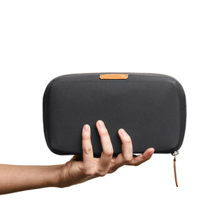 Bellroy Tech Kit held in hand showing black recycled fabric exterior with leather zipper pull detail