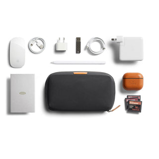 Bellroy Tech Kit in charcoal black with accessories including cables, charger, and memory cards neatly arranged
