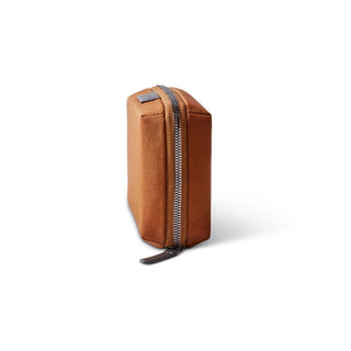 Bellroy Tech Kit Compact in brown recycled fabric with silver zipper, standing upright on white background