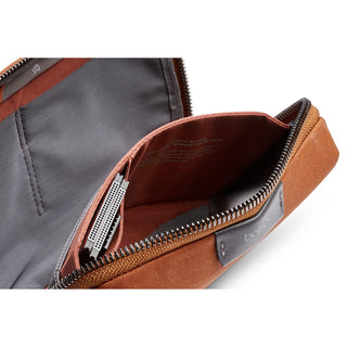Bellroy Tech Kit Compact in rust fabric with organized compartments and metal zipper detail open angle view