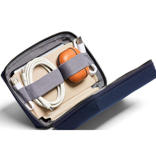Bellroy Tech Kit Compact open showing organized cables and accessories in navy recycled fabric case