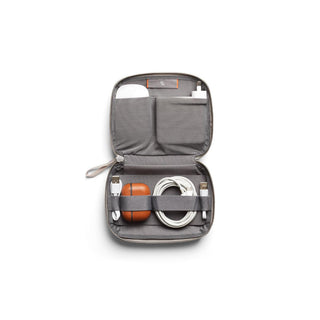 Bellroy Tech Kit Compact opened showing organized tech accessories inside gray recycled fabric pouch