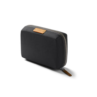 Bellroy Tech Kit Compact in black recycled fabric with leather zipper pull and logo patch, angled view