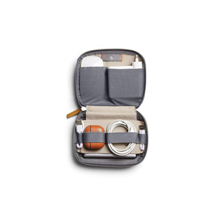 Bellroy Tech Kit Compact open with organized compartments holding cables and tech accessories in recycled fabric