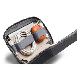 Bellroy Tech Kit Compact opened showing organized cables and compact charging accessories inside black fabric case