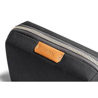 Bellroy Tech Kit Compact in black recycled fabric with leather logo and silver zipper close-up view