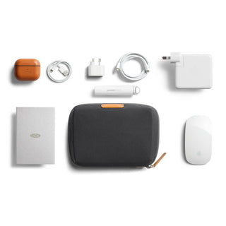 Bellroy Tech Kit Compact in charcoal fabric with tan leather pull and tech accessories neatly arranged