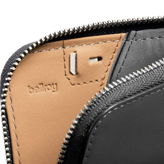 Bellroy Card Pocket showing tan leather interior with embossed logo and silver zipper detail