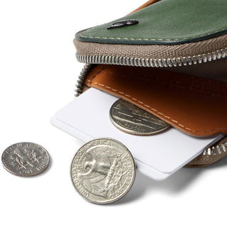 Bellroy Card Pocket with green leather top and tan interior holding cards alongside three US coins