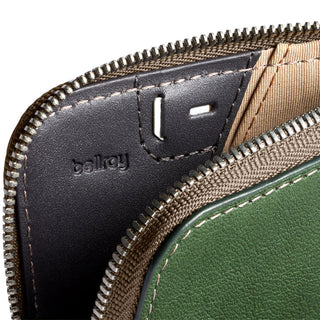 Bellroy Card Pocket close-up showing green leather exterior and black interior with zipper detail
