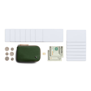 Bellroy Card Pocket in green leather shown with cards, cash, coins, and a SIM card next to it on white background