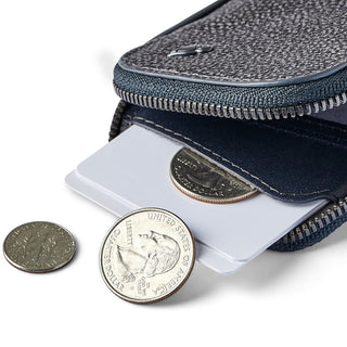 Bellroy Card Pocket in textured dark fabric with a zipper, holding cards and coins partially visible