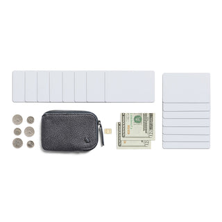 Bellroy Card Pocket in black leather with zipper, surrounded by cards, cash, and coins on white background