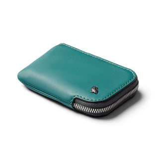 Bellroy Card Pocket in teal leather with silver zipper and compact stitched design on white background