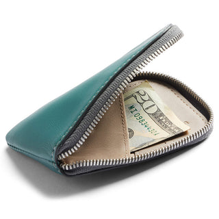 Bellroy Card Pocket in teal leather with zipper, partially open showing folded cash inside.